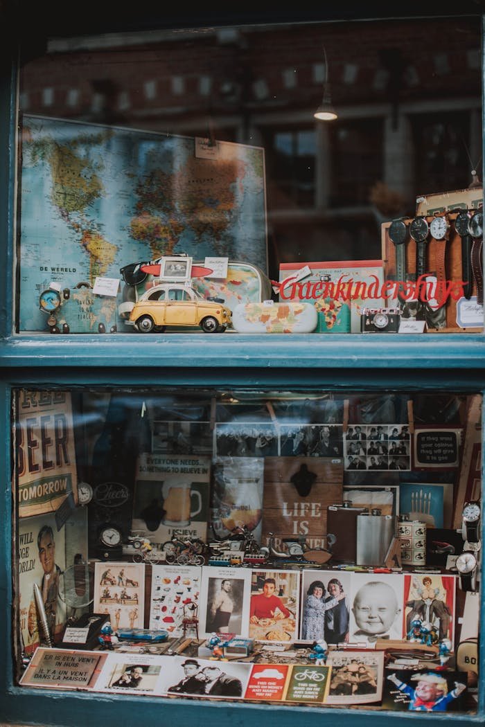 Charming window showcasing vintage maps, toy cars, and memorabilia in Brussels.